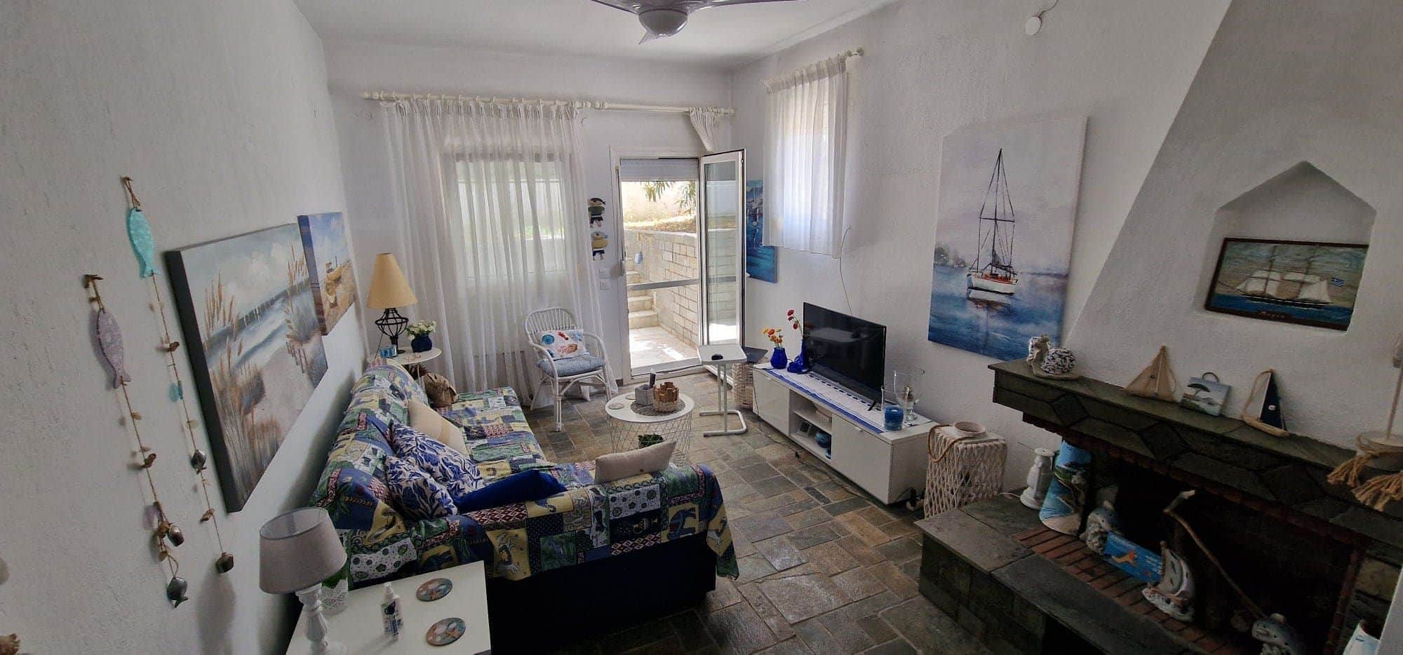 Modern interior of a Greek coastal house with white stone floors and minimalist summer decor